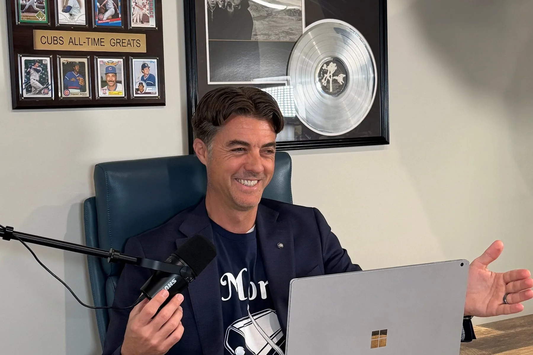 Jason A. Marker recording The Briefcase and the Beat podcast at the Marker Law office, with his Cubs All-Time Greats plaque and a platinum record on the wall