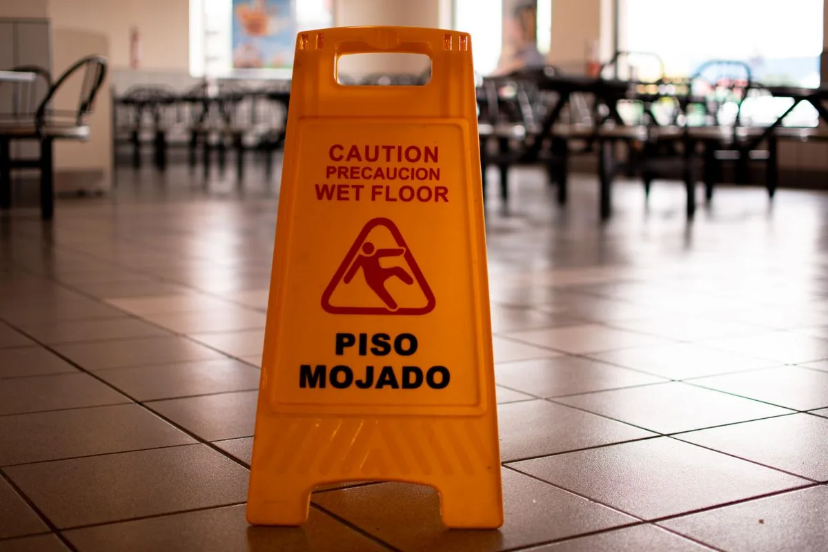Bilingual wet floor caution sign in a public building