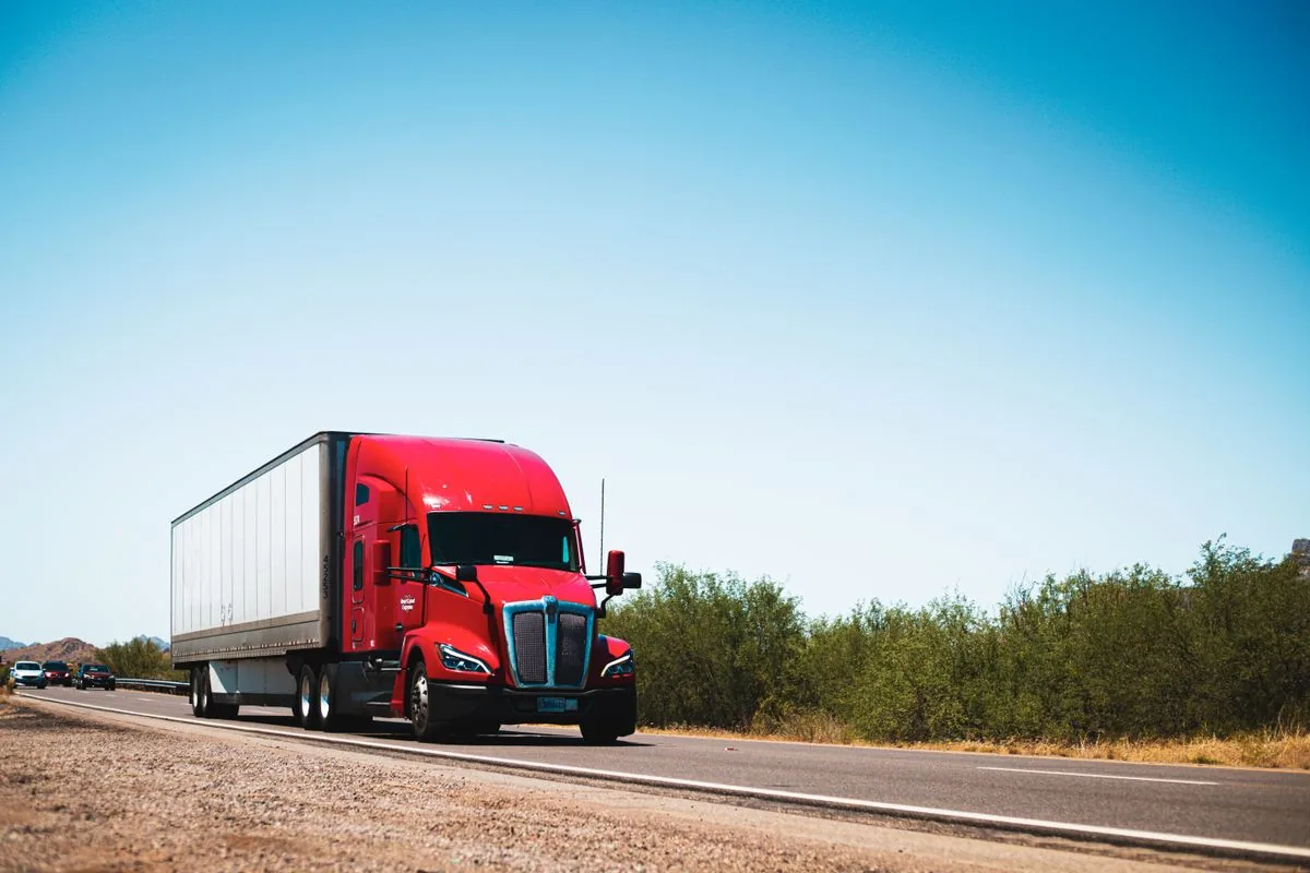 Red semi-truck hauling a trailer along an open highway